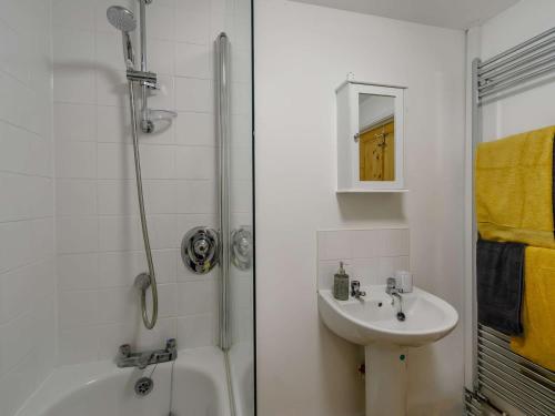 a white bathroom with a sink and a shower at 1 Bed in Saltash 89873 in Pillaton