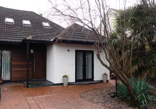 a white house with a brown roof and a driveway at Stunning guest house in Frenchay in Bristol