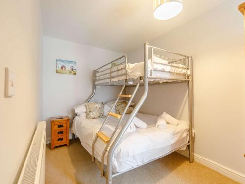 a bedroom with two bunk beds and a ladder at 3 Bed in Newquay 89941 in Mawgan Porth