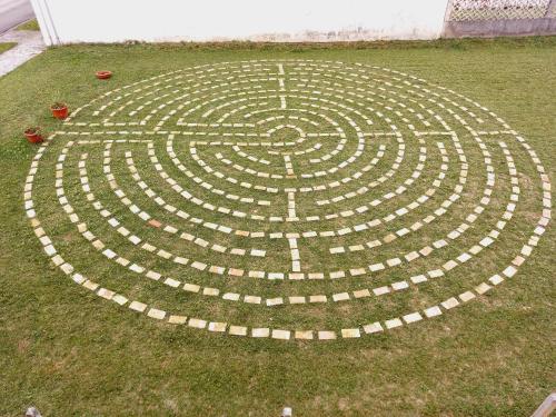a labyrinth in the grass in a garden at Casa Ortensia in Grions