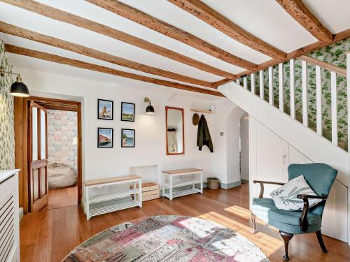 ein Wohnzimmer mit Holzdecken und einem blauen Stuhl in der Unterkunft 3 Bed in Amberley 89898 in Woodchester