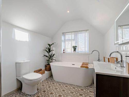 ein Badezimmer mit einer Badewanne, einem WC und einem Waschbecken in der Unterkunft 3 Bed in Amberley 89898 in Woodchester