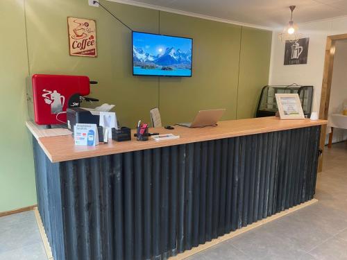 an office counter with a desk with a laptop on it at Terra Hostal in Puerto Natales
