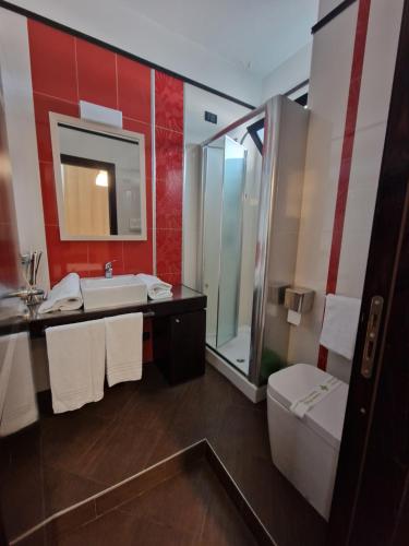 ein Badezimmer mit einem Waschbecken, einem WC und einem Spiegel in der Unterkunft Boteco B&B in Bacoli
