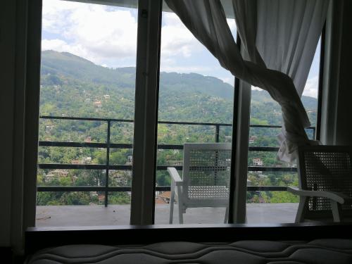 a room with a window with a view of the mountains at Glenview hotel & homestay in Kandy