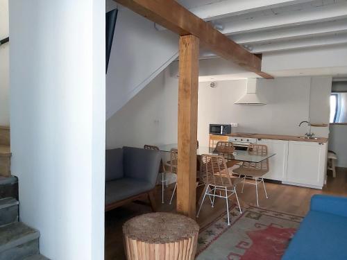 Una sala de estar y una cocina con un sofá y una mesa. en CASAS DA FORTALEZA Casa do Garda, en Outeiro de Rei
