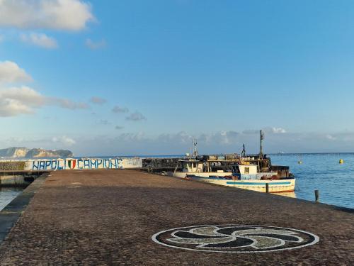 a pier with two boats in the water at Boteco B&B in Bacoli