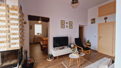 a living room with a television and a fireplace at Seva Monolithos house in Monólithos