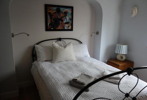 una camera da letto con un letto con lenzuola bianche e una foto di Stunning guest house in Frenchay a Bristol