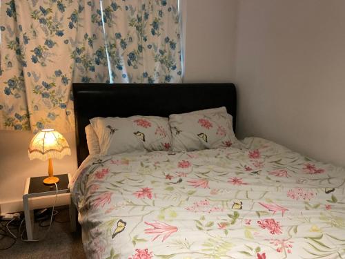 a bedroom with a large bed with flowers on it at Feel at home in Abbey Wood
