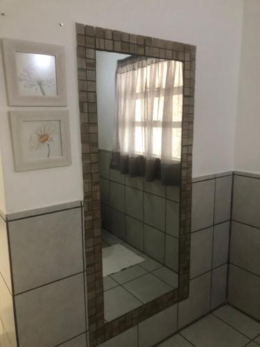 a shower with a mirror in a bathroom at Kellys Corner in Lydenburg