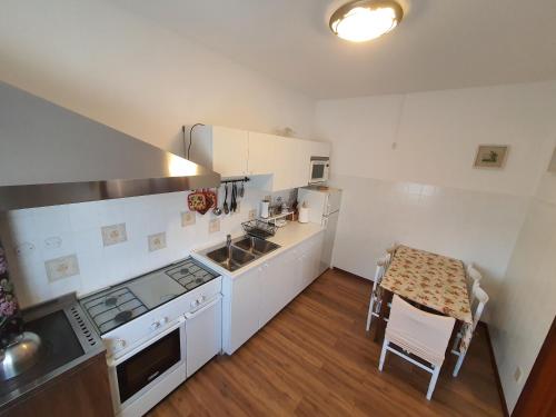 a small kitchen with white appliances and a table at Casa Ortensia in Grions
