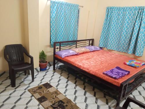 ein Schlafzimmer mit einem Bett und einem Stuhl darin in der Unterkunft Royal home homestay in kolkata