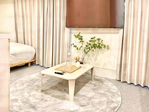 a living room with a table with a plant on it at 上野超豪华4人间 东京超级中心Ydoa 设计师房间 上野公园3分钟 车站1分钟 超级繁华 免费wifi 戴森吹风 in Tokyo