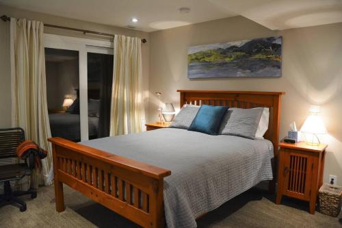 a bedroom with a wooden bed with blue pillows at Spiritview Bellevue in Bellevue