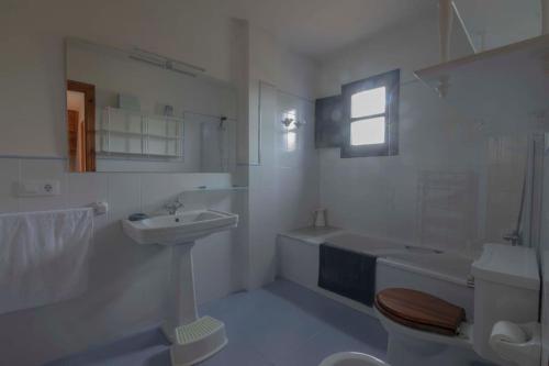 La salle de bains blanche est pourvue d'un lavabo et de toilettes. dans l'établissement Llanes: Casa Azul de Pancar, à Pancar