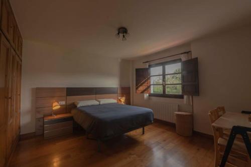 - une chambre avec un lit, une table et une fenêtre dans l'établissement Llanes: Casa Azul de Pancar, à Pancar