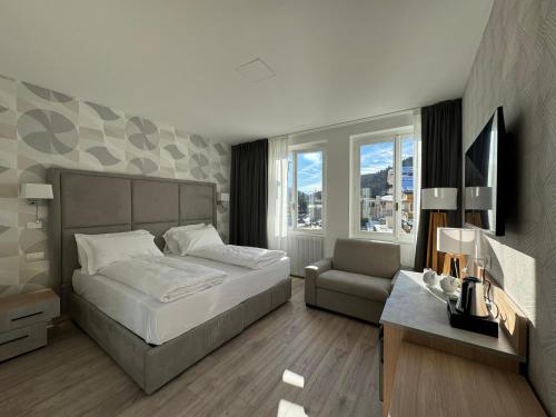 Hotel Rosengarten في مادونا دي كامبيليو: غرفة نوم بسرير واريكة وكرسي