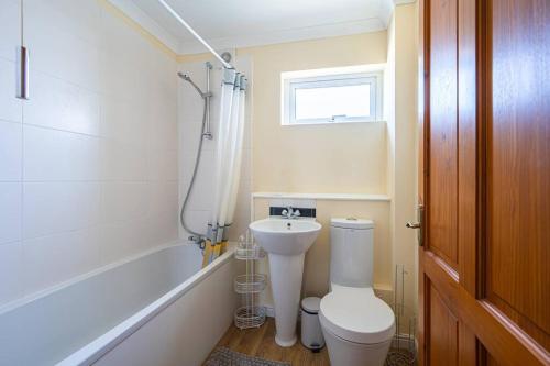 a bathroom with a toilet and a sink and a bath tub at Cosy 3-Bed Close to City Centre with Free Parking in Ipswich