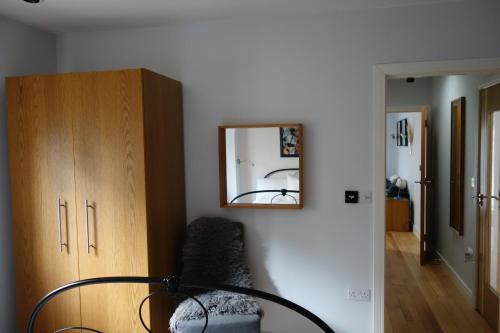 um quarto com um espelho, uma cadeira e um armário em Stunning guest house in Frenchay em Bristol
