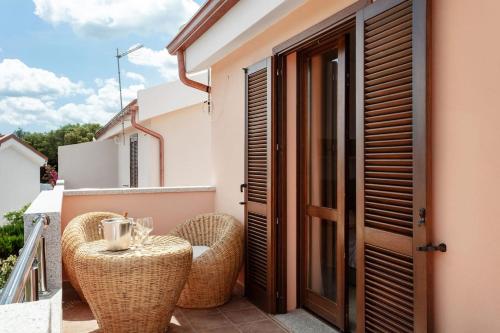 balcón con sillas de mimbre y mesa en el balcón en Tortuga House - private Jacuzzi -, en Telti