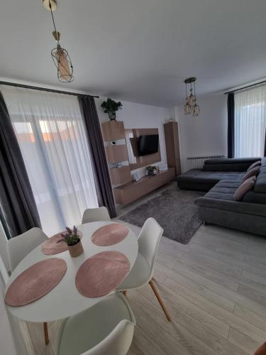 sala de estar con mesa blanca y sillas en Daric Residence Apartaments, en Fălticeni