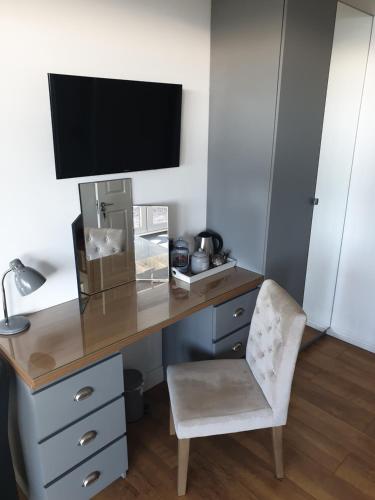 a desk with a chair and a television on it at The Waters Edge in Lee-on-the-Solent
