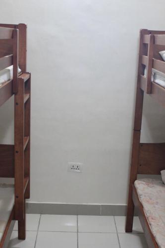 a room with two bunk beds and a white wall at BnT Inn in Mactan