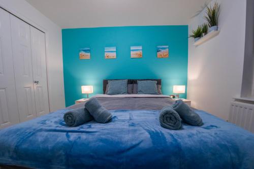 ein blaues Schlafzimmer mit einem großen Bett mit blauen Wänden in der Unterkunft Spacious & Central Ground Floor Apt in Royal Tunbridge Wells
