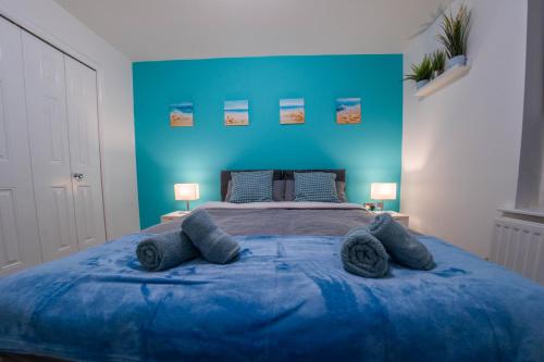 a blue bedroom with a large bed with blue walls at Spacious & Central Ground Floor Apt in Royal Tunbridge Wells