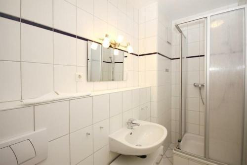キュールングスボルンにあるStrandschloesschen-Haus-II-WE-18-9723の白いバスルーム(シンク、シャワー付)