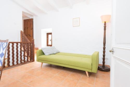 a green couch in a room with a staircase at Can Bessó Mancor de la Vall in Mancor del Valle