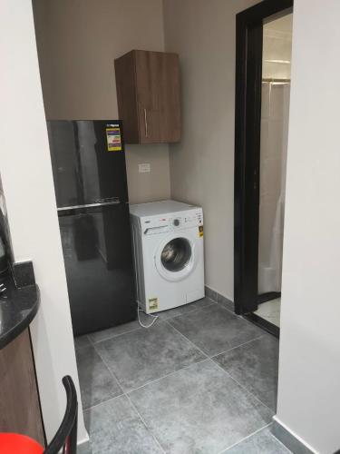 a kitchen with a washing machine and a refrigerator at Luxury Host -219- Dream Land in 6th Of October