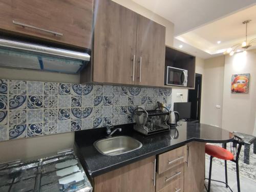 a kitchen with a sink and a microwave at Luxury Host -219- Dream Land in 6th Of October