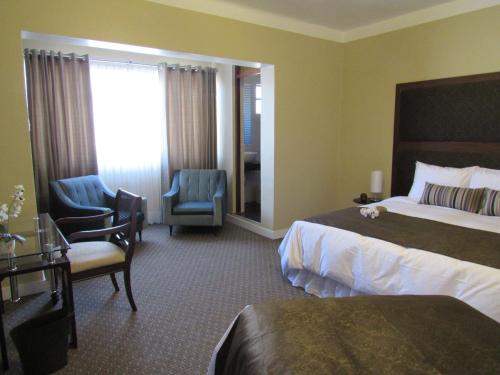 a hotel room with a bed and two chairs at Los Leones Hotel Boutique in Arequipa