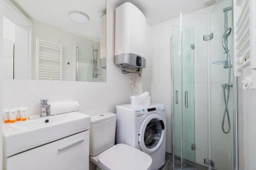 a white bathroom with a washing machine and a sink at Solna Studio Cracow by Renters in Krakow