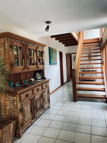 Großes Zimmer mit Holzschränken und einer Treppe in der Unterkunft Casa ampla em condomínio fechado com área de lazer completa in Búzios