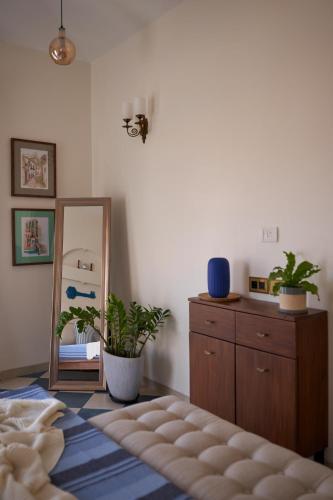 a bedroom with a mirror and a dresser with plants at LohonoStays Villa Aurelia E in Vagator