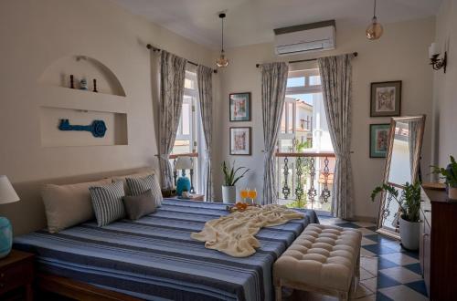 a bedroom with a large bed and a couch and windows at LohonoStays Villa Aurelia E in Vagator