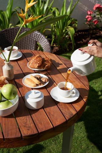 a table with cups of coffee and food on it at LohonoStays Villa Aurelia E in Vagator