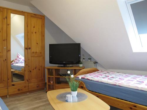 a bedroom with a bed and a tv on a table at Ferienwohnung ERNA HORS110 in Wangerland