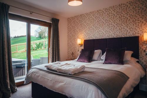 a bedroom with a large bed with a large window at Beautiful cottage in idyllic countryside setting in Montgomery