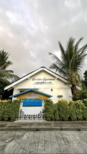 a white building with palm trees in front of it at LindenApartment 