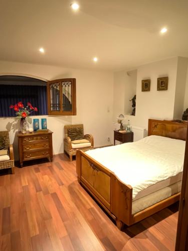 um quarto com uma cama e piso em madeira em Le Domaine des Anges 
