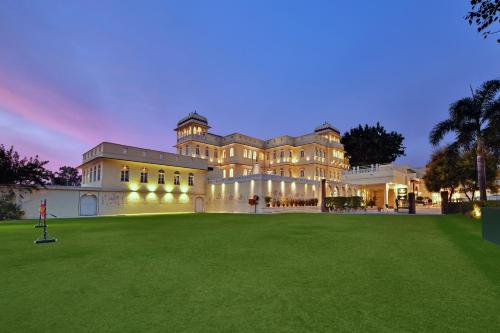 een groot gebouw met een groen gazon ervoor bij WelcomHeritage Ramgarh in Panchkula
