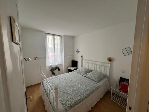 une chambre avec un lit blanc et une fenêtre dans l'établissement Luxe et charme Méditerranéen face à la promenade des Anglais, à Nice