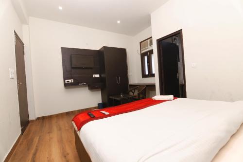 um quarto com uma cama e uma televisão na parede em Green View Residency em Greater Noida