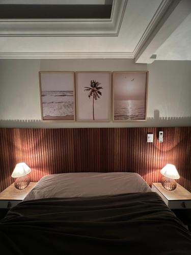 a bedroom with a bed with three pictures on the wall at Triplex Vista Azul in Rio das Ostras
