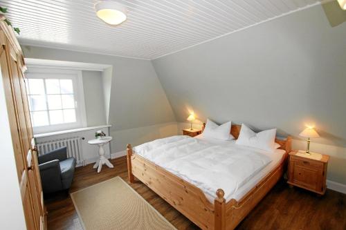 um quarto com uma cama, uma cadeira e uma janela em Steffi - Ostmarkstr 20, App 2 em Wenningstedt