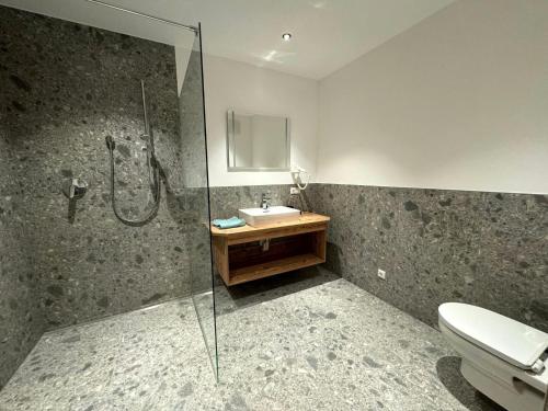 uma casa de banho com um chuveiro, um lavatório e um WC. em Amazing Apartment with private garden em Neustift im Stubaital